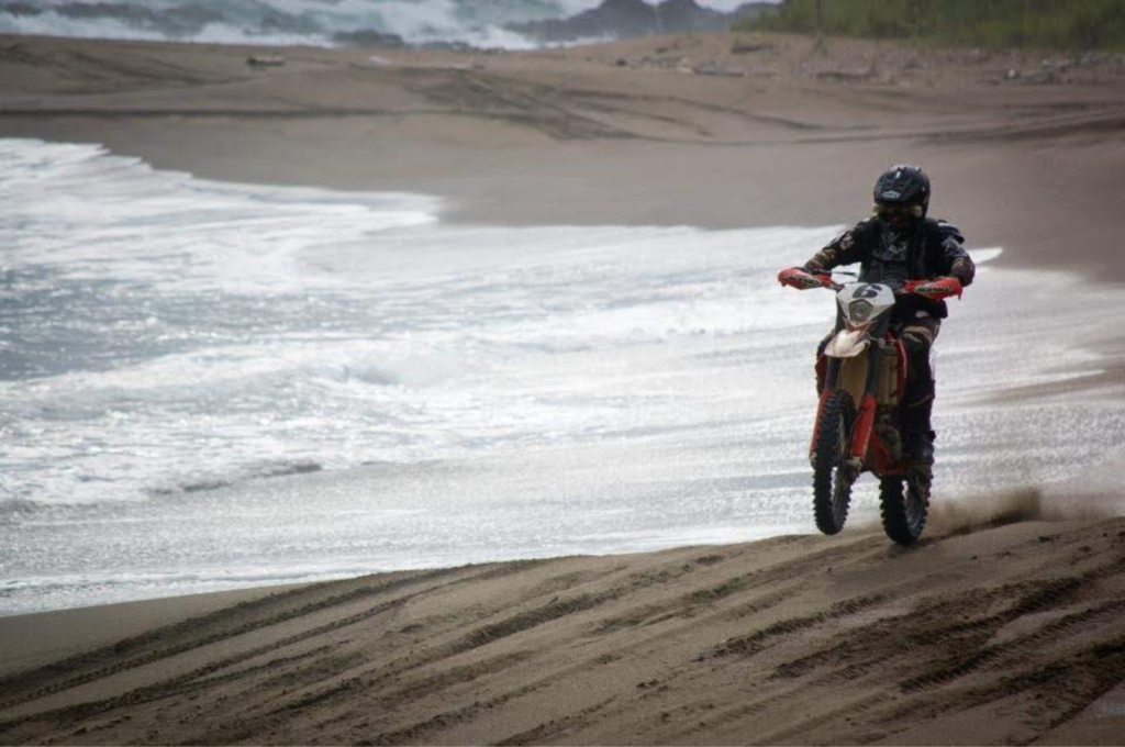 Photo moto roulant sur le sable à coté de la mer